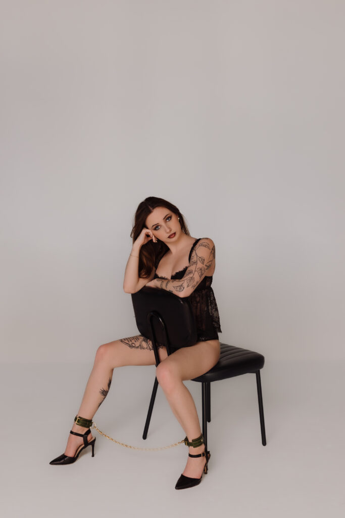 Boudoir photo by Oklahoma City photographer, Crystal Shaw, featuring green leather cuffs with gold connecting chain from Lovey Subby.